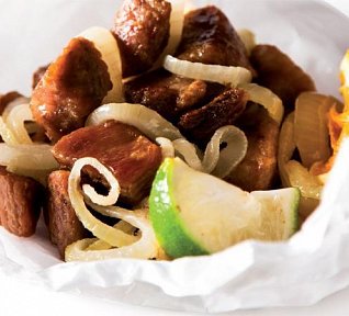 Smažené vepřové kousky s cibulí na citrusech